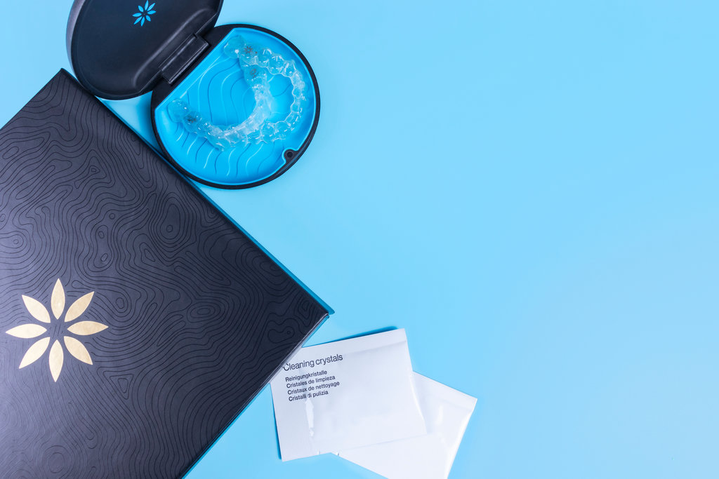 Invisible transparent aligners invisalign blue package with a box, clear-plastic retainers and cleaning crystals.