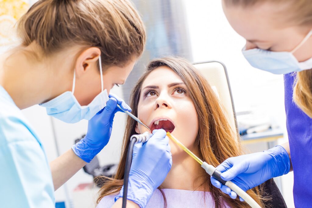 Male dentist examining patient teeth before oral operation