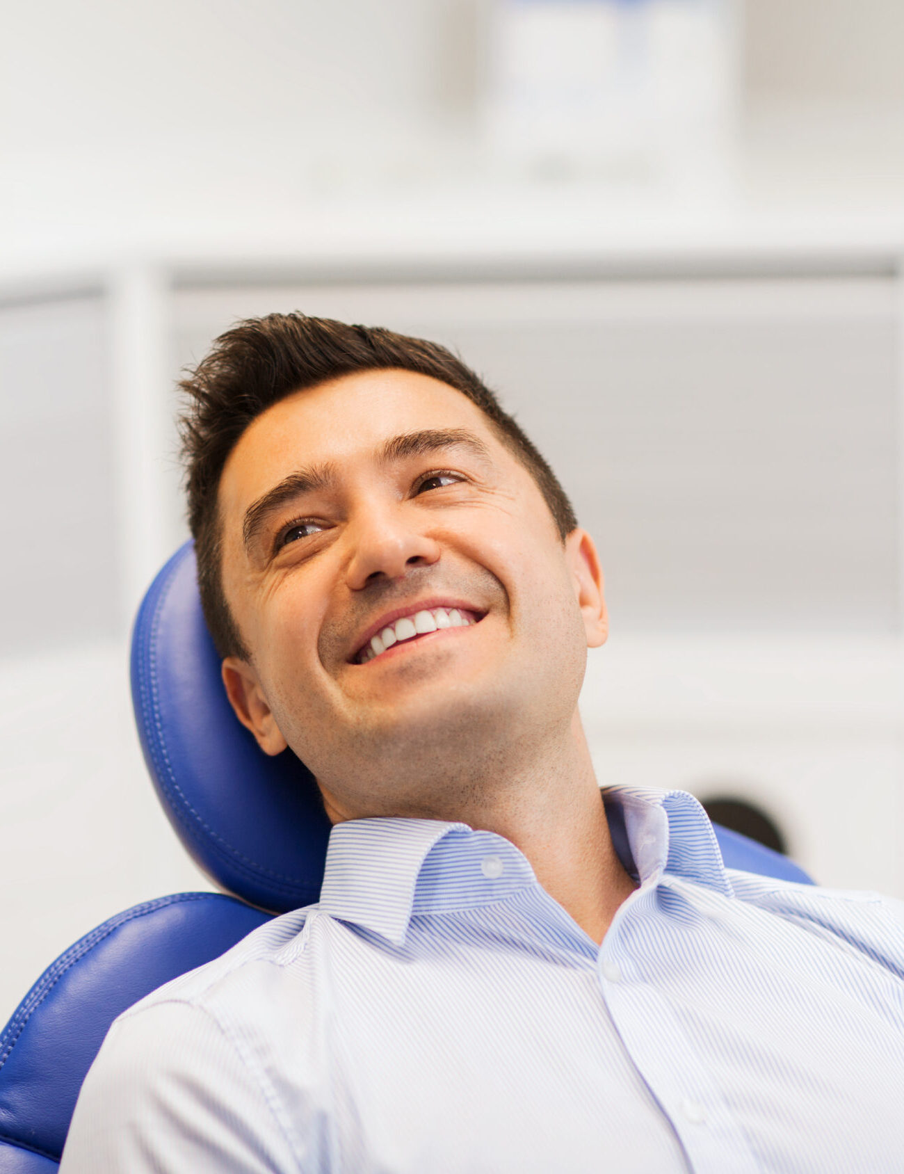 people, medicine, stomatology and health care concept - female dentist talking to happy male patient at dental clinic office