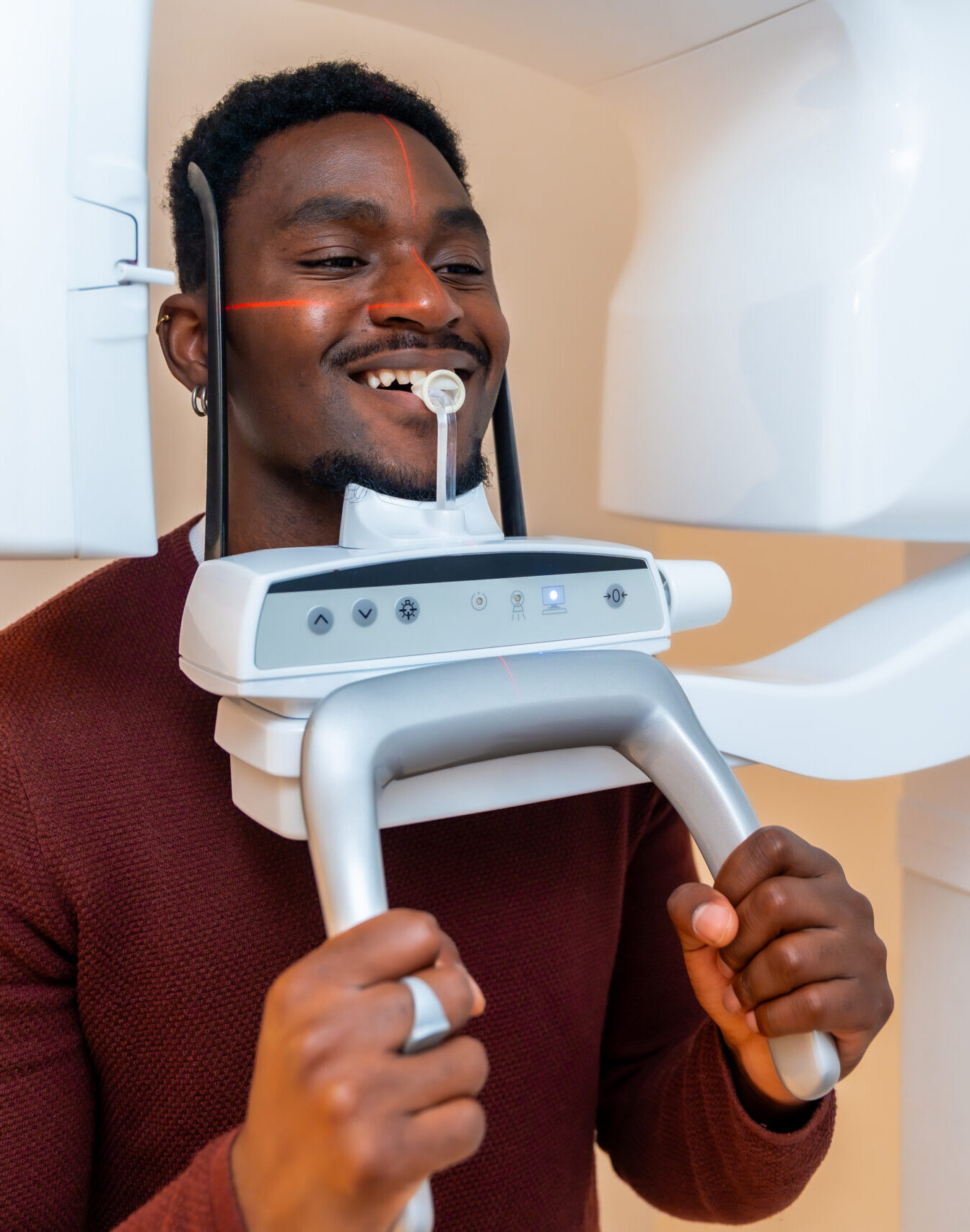 Patient smiles while undergoing a dental x ray scan in a modern dental clinic, demonstrating advanced oral healthcare technology