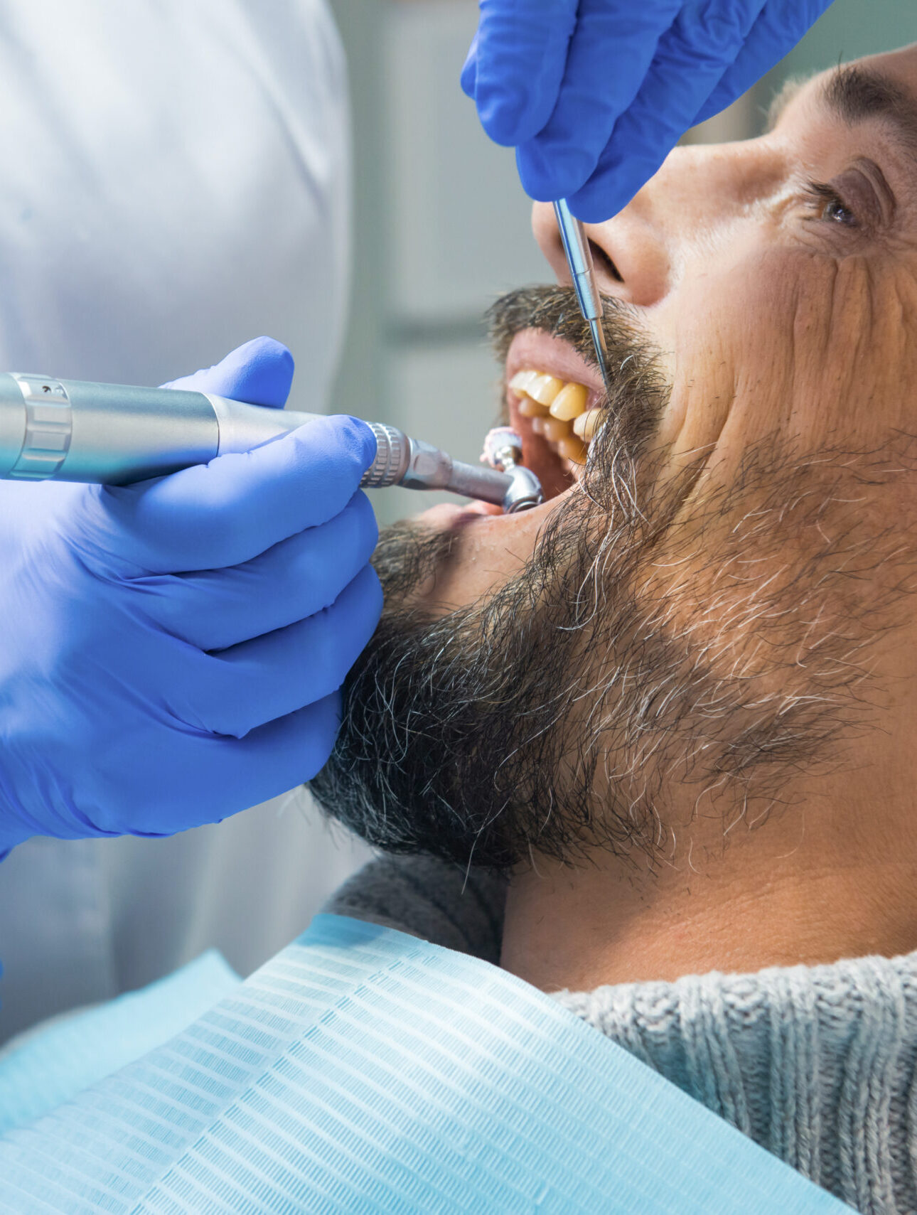 Dentist cleaning teeth. Hands of stomatologist with tools. Dental health services.