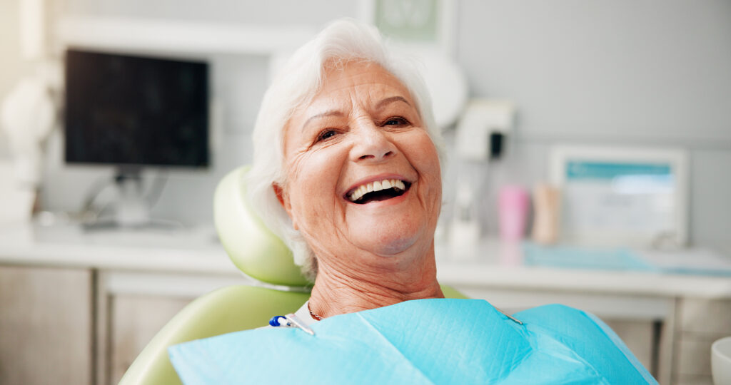 Portrait, smile and senior woman at dentist for teeth whitening results, dentures or oral hygiene. Healthcare, chair and elderly patient in clinic for root canal treatment, dental implants or filling.