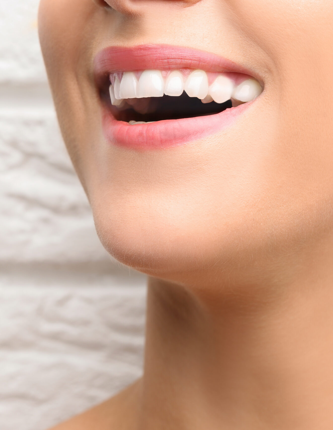 Young beautiful woman with healthy teeth smiling on light background