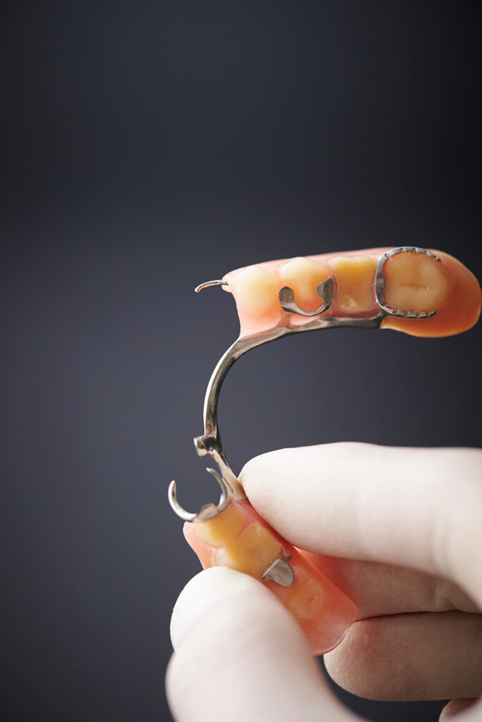 Hand holding false tooth