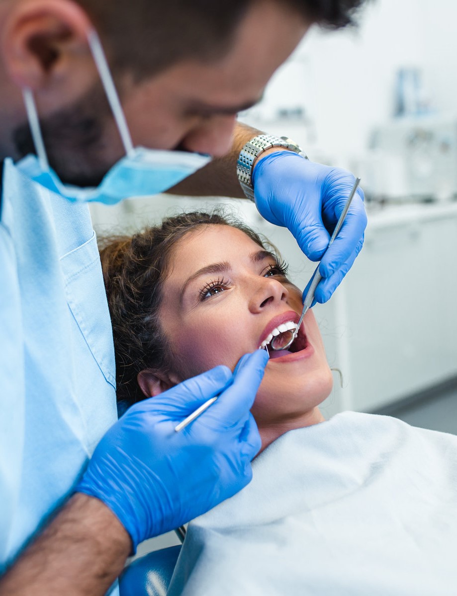 Beautiful young woman having dental treatment at dentist's office.