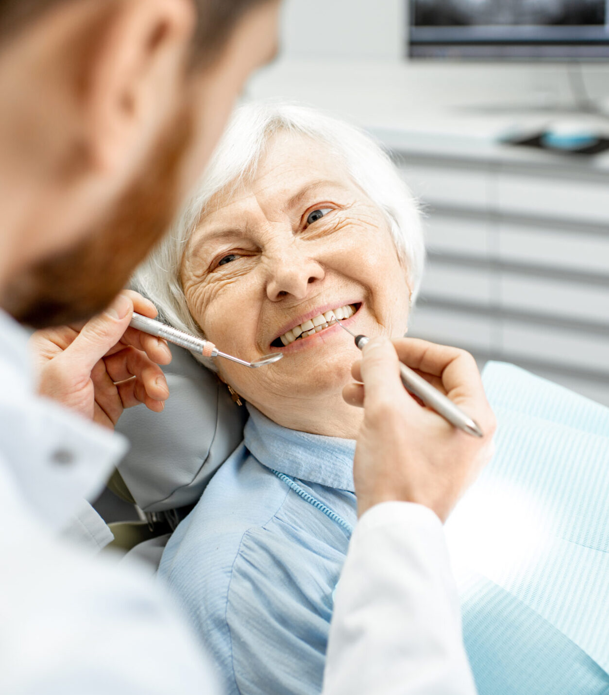 Elderly woman during the medical examination with male dentist in the dental office