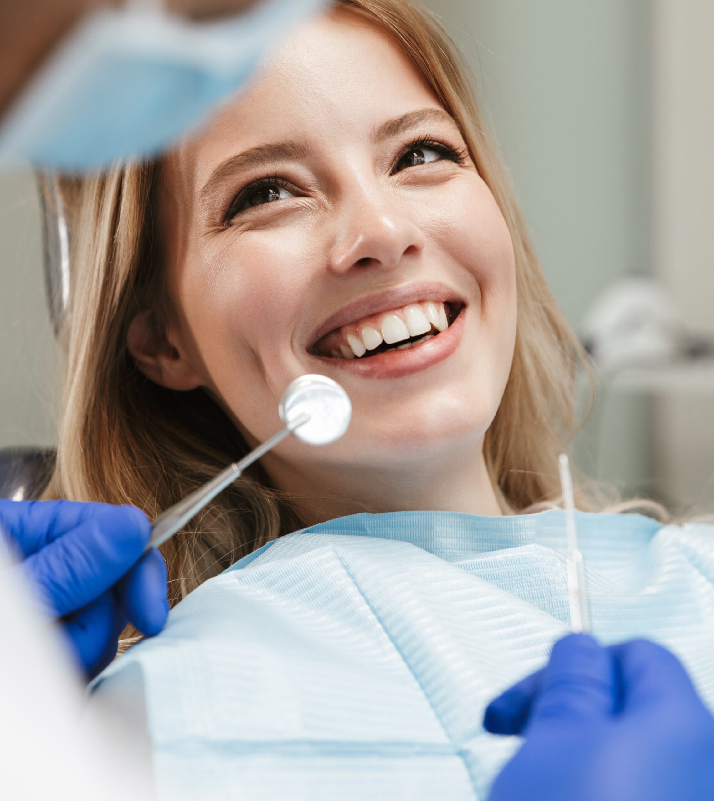 Image of pretty woman sitting in dental chair while professional doctor fixing her teeth
