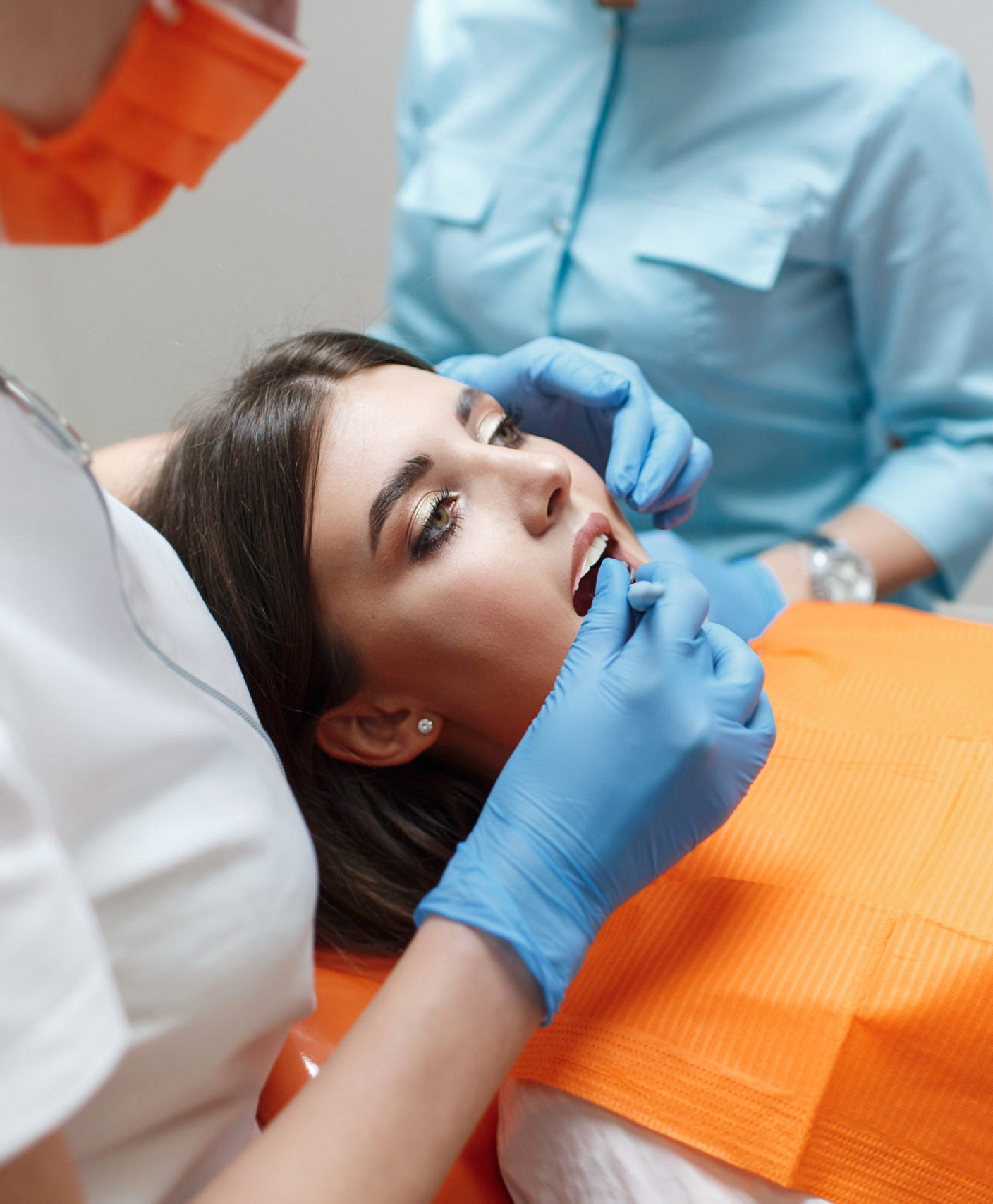 Dentist and assistant treat a patient's tooth.Doctor dentist treats teeth of a beautiful young girl patient. Doctor dentist treats tooth.Beautiful smile. The client in the dental chair.