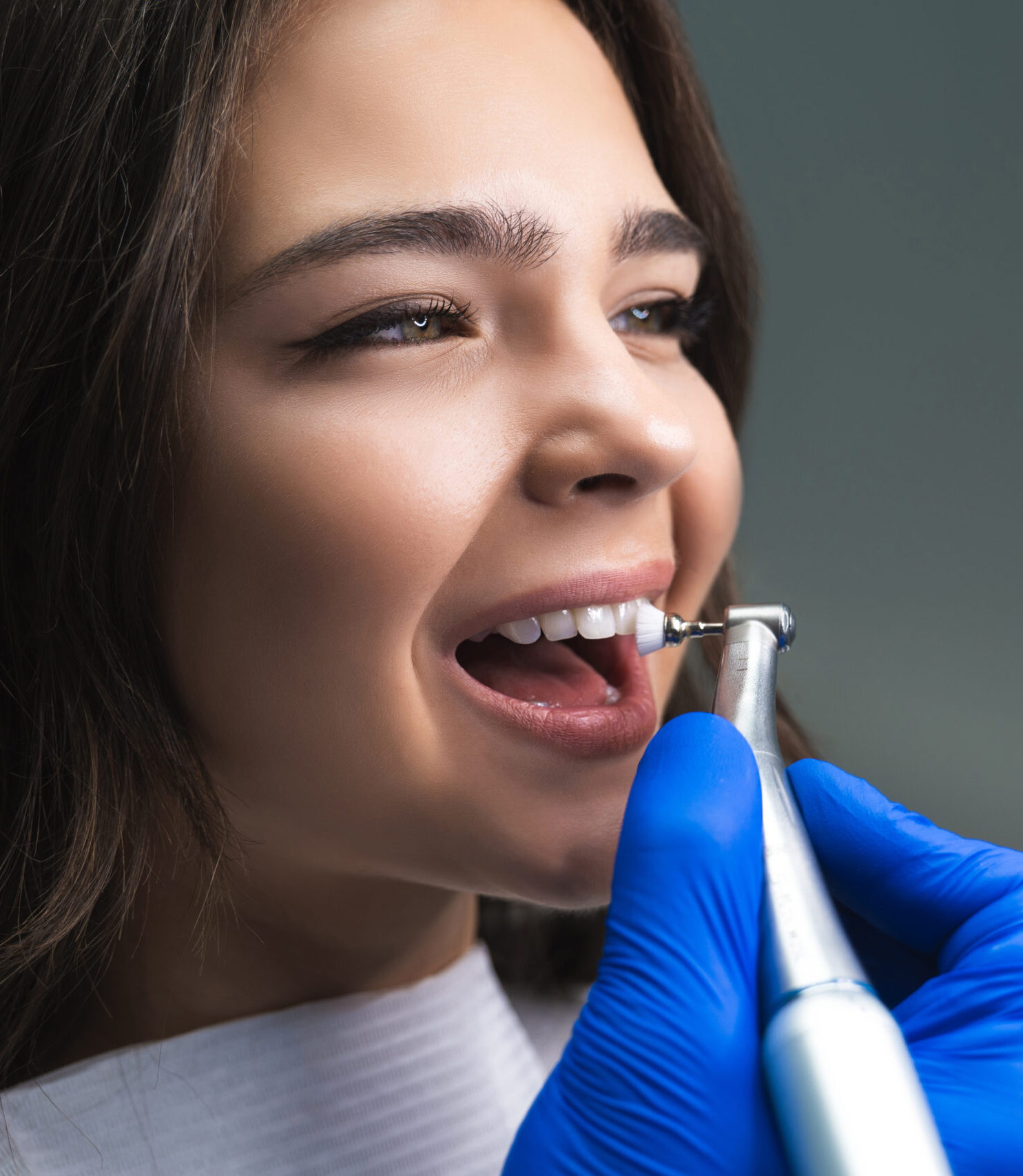 process of using dental brush as a stage of professional dental cleaning procedure in clinic close up.