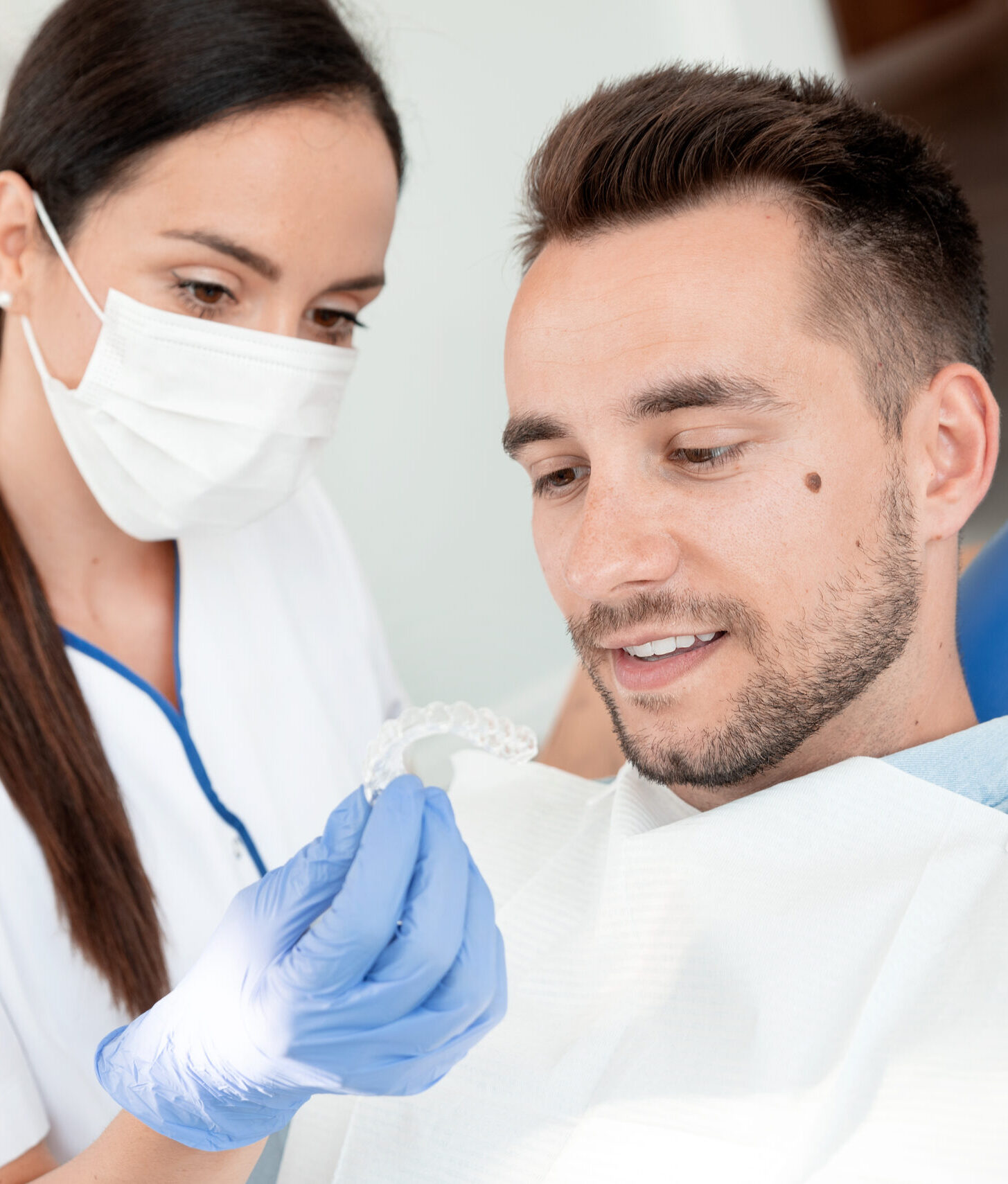 Dentist shows invisible braces aligner. Dental consultation in an orthodontic clinic