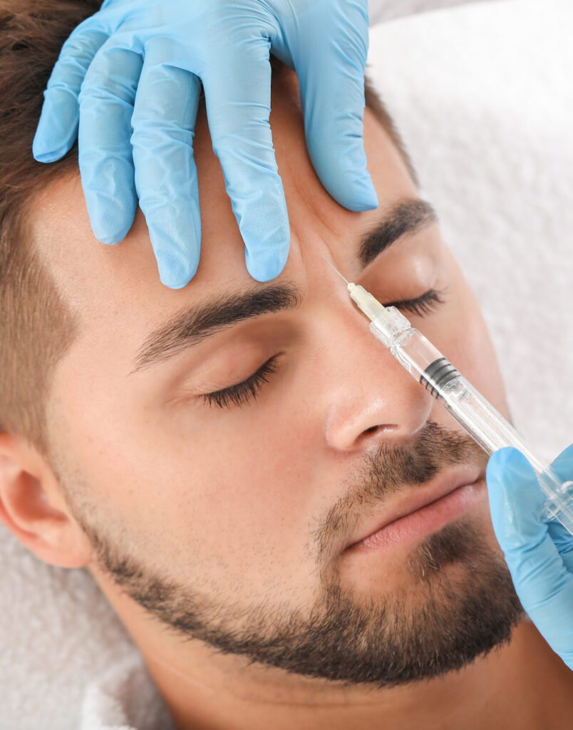 Handsome man receiving filler injection in beauty salon