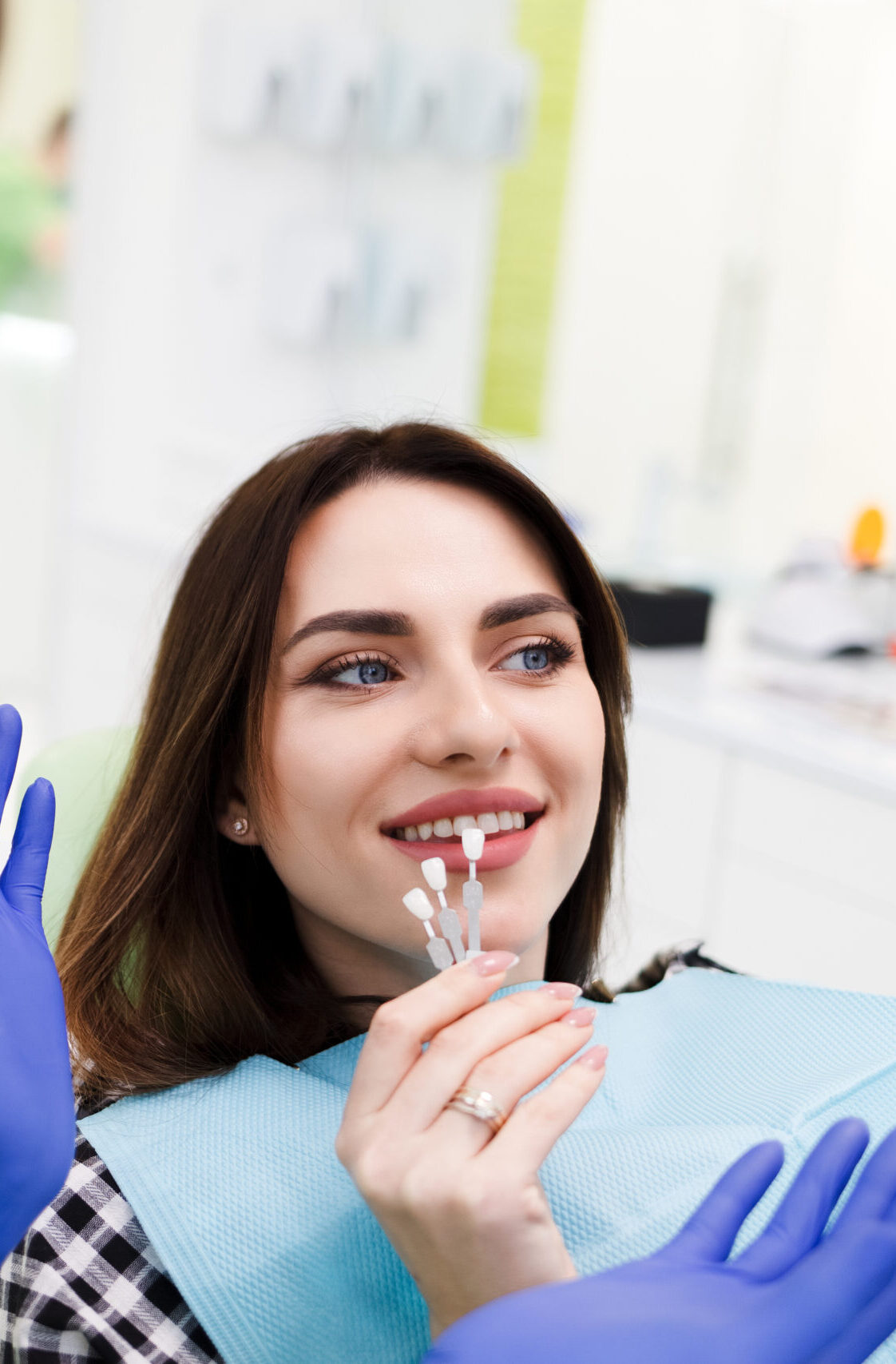 Girl chooses color of veneers at the dentist office
