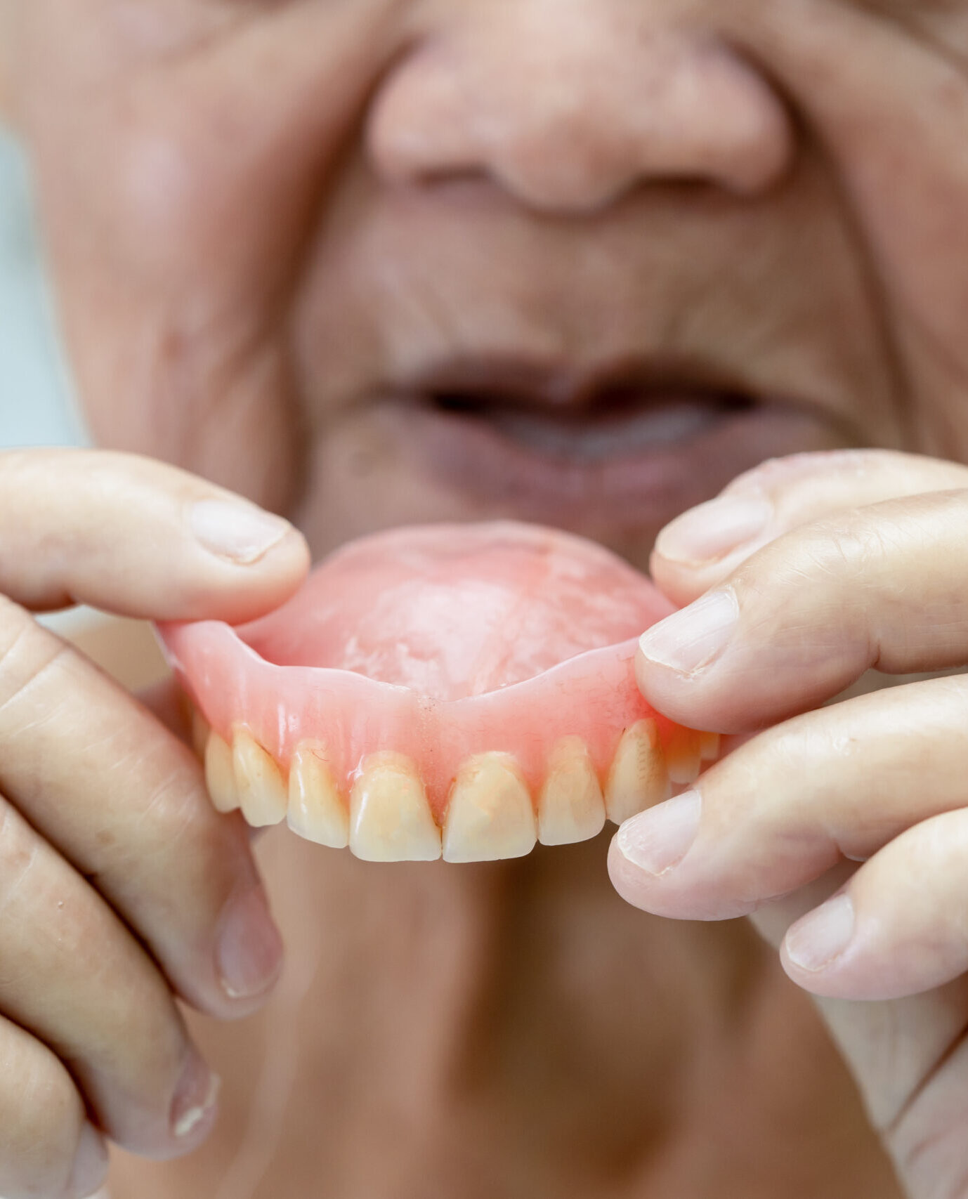 Asian senior or elderly old woman patient holding to use denture in nursing hospital ward, healthy strong medical concept