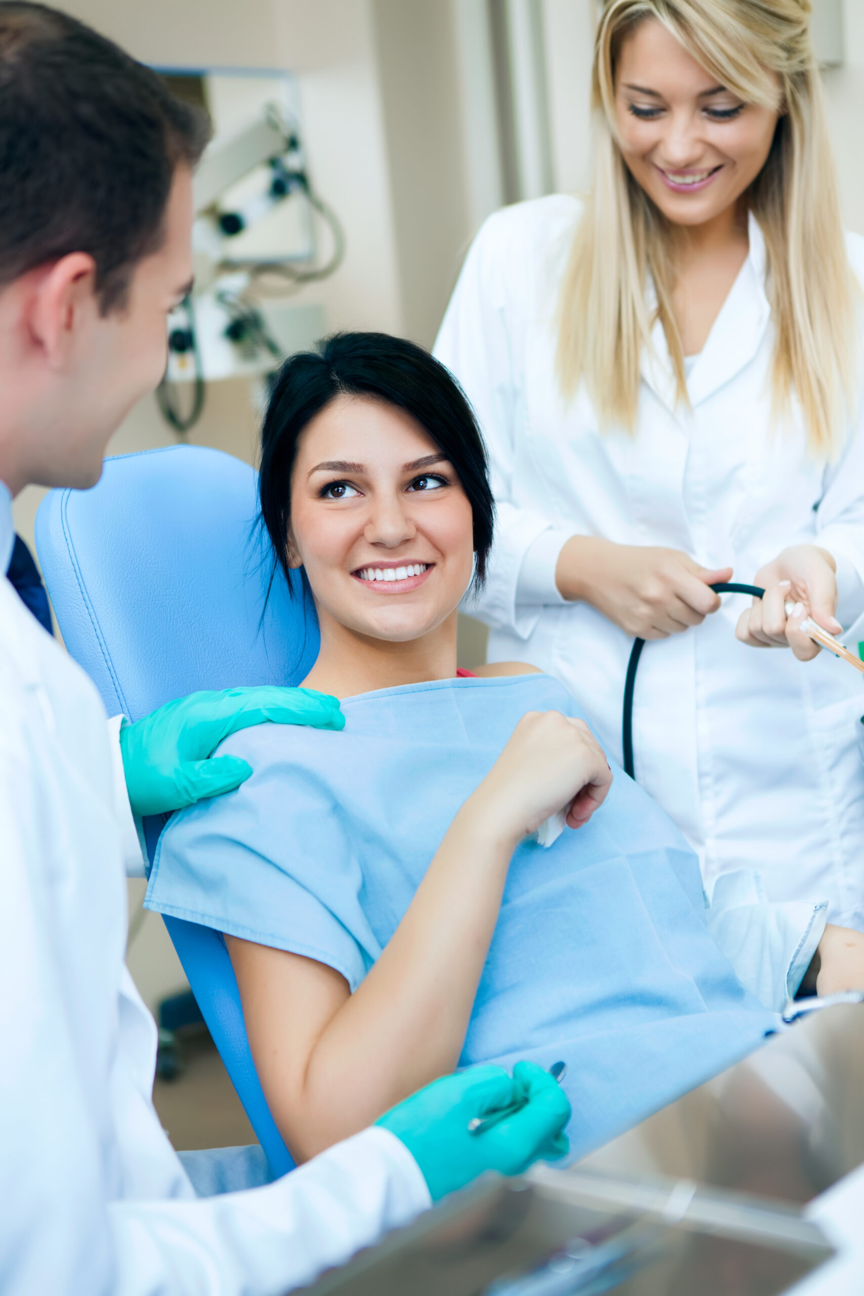 Patient at a dentist office with doctor and assistant