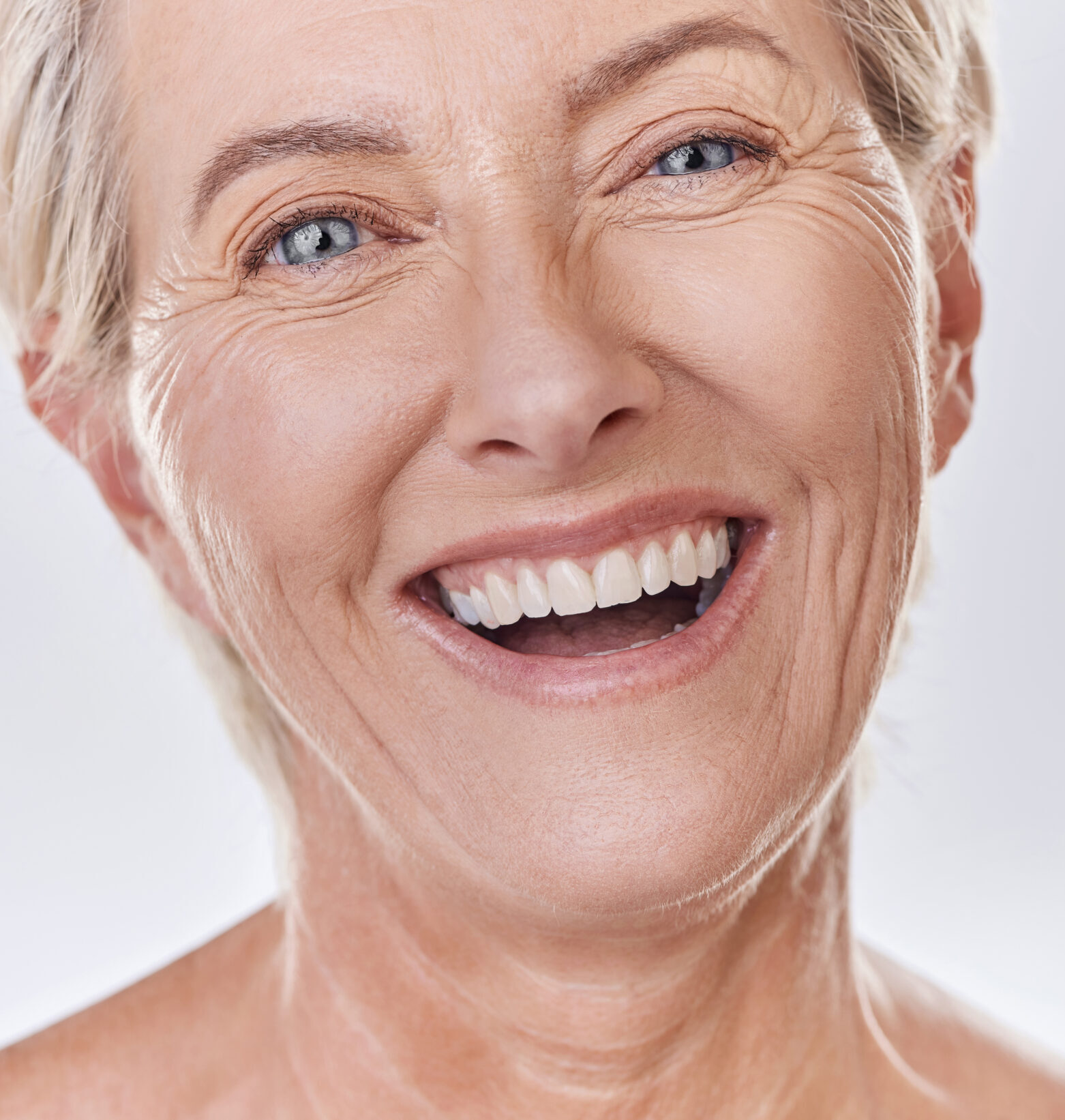 Dentist, veneers or dentures in senior woman mouth or teeth looking happy with her oral hygiene or dental cleaning cosmetic service. Mature model with smile on face for dentistry, health and wellness.