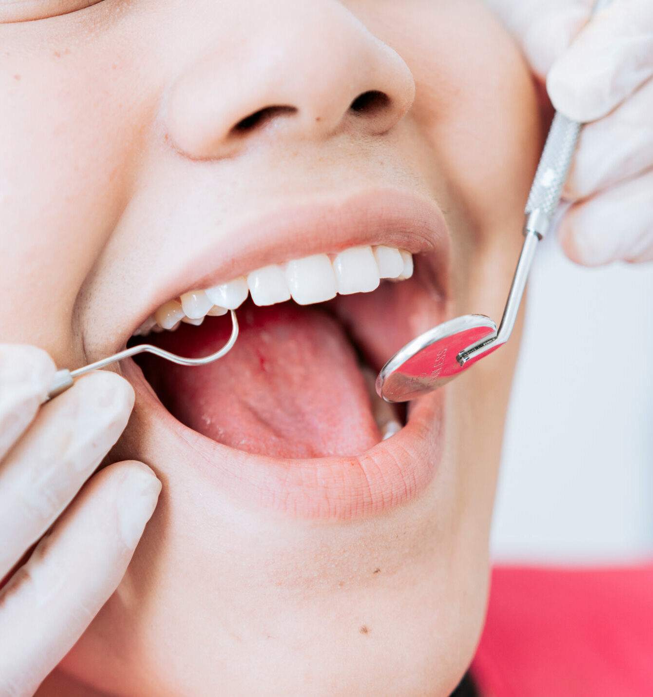 Hands of a specialist dentist cleaning the teeth of a female patient. Close up of dentist hands cleaning patient. Close-up of the hands of a dentist cleaning the teeth of a female patient