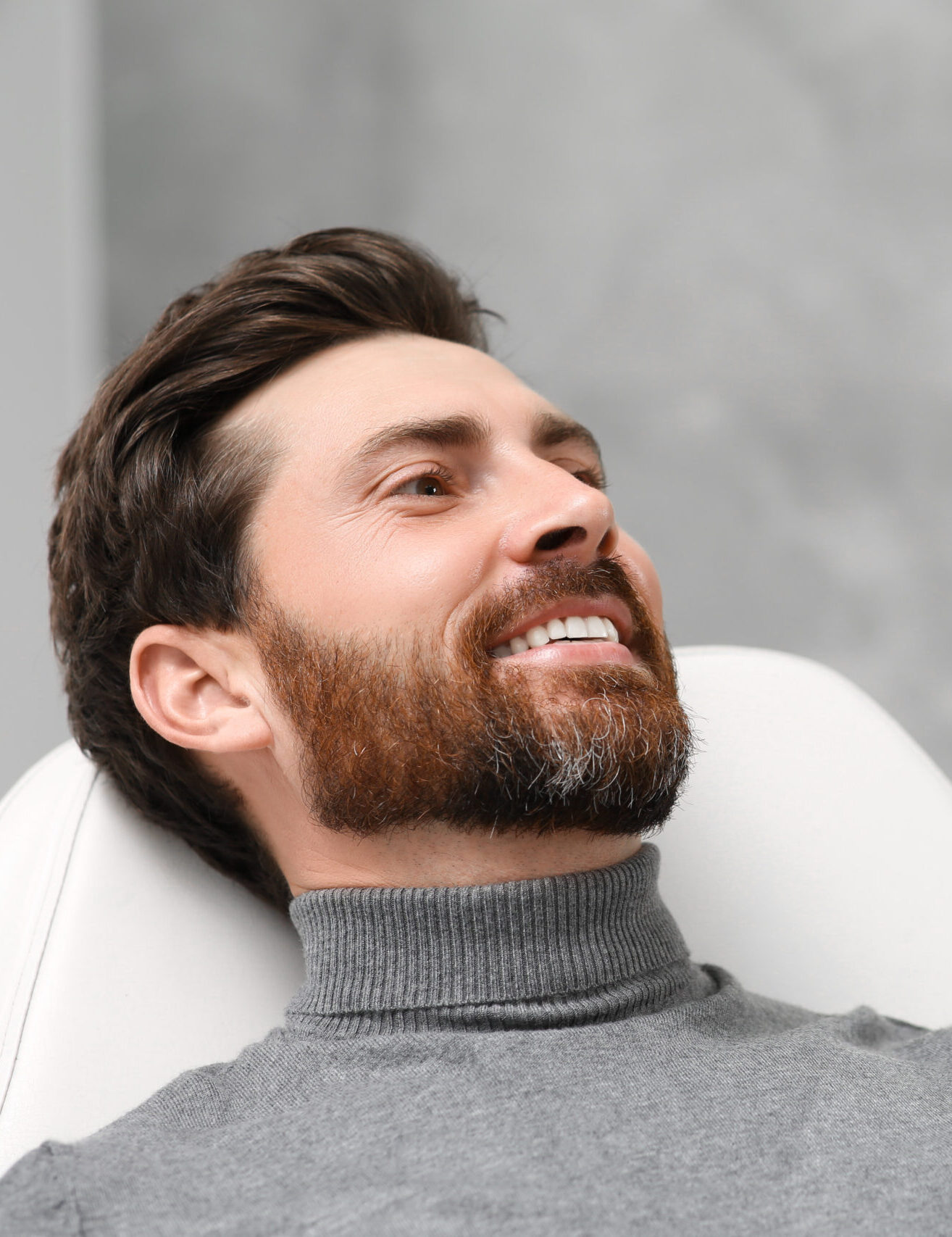 Man looking at his new dental implants in mirror indoors