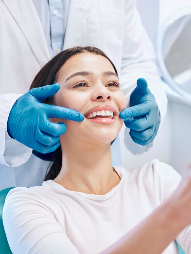 Dental consultation, mirror and woman with smile after teeth whitening, service or mouth care. Healthcare, dentistry and happy female patient with orthodontist for oral hygiene, wellness and cleaning.