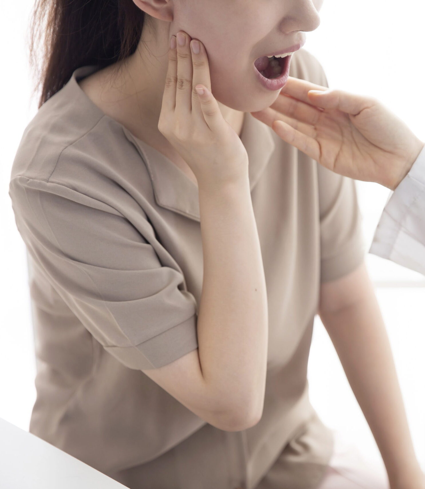 Doctor checking patient's toothache in office