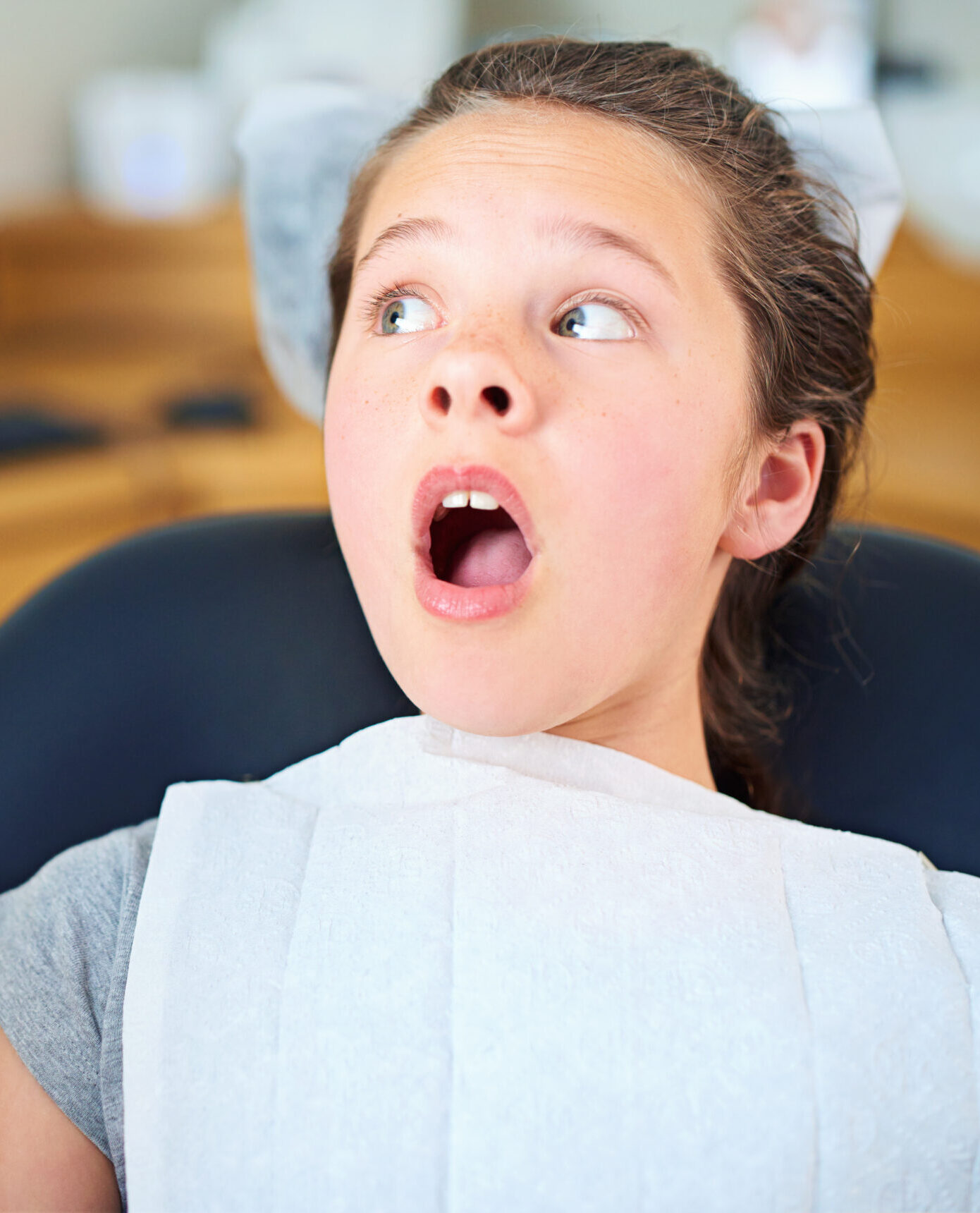 Dental, wow or scared girl in consultation room with phobia, worry or fear for dentist exam. Orthodontics, stress or teen person nervous for teeth, cavity or bacteria, risk or gum disease emergency.