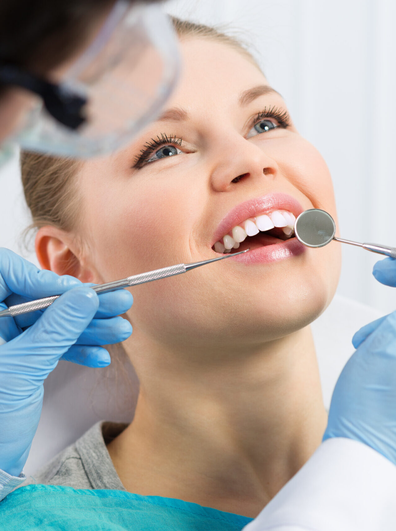 Male dentist examining patient teeth before oral operation