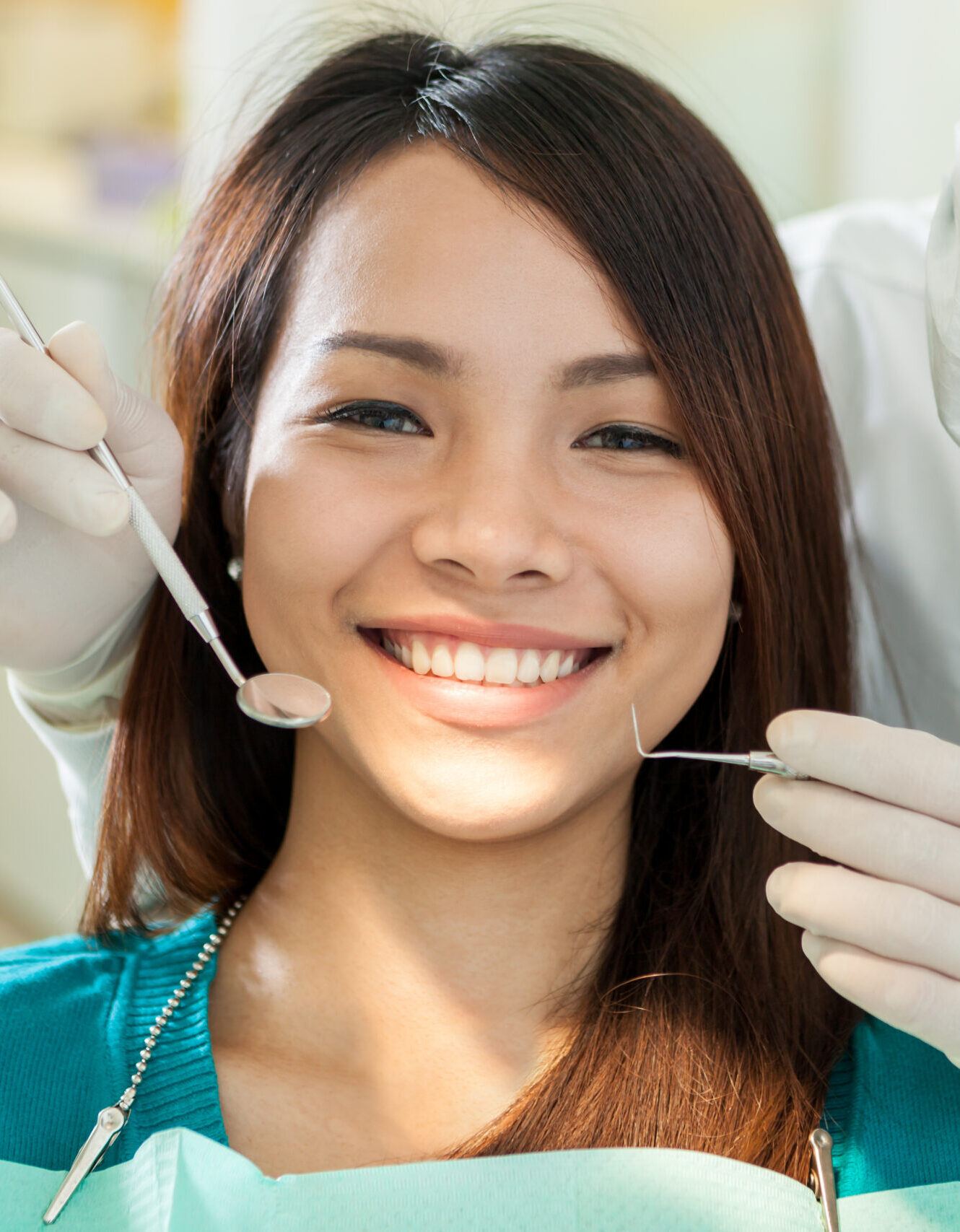 Portrait of smiling asian woman sitting at the dentist