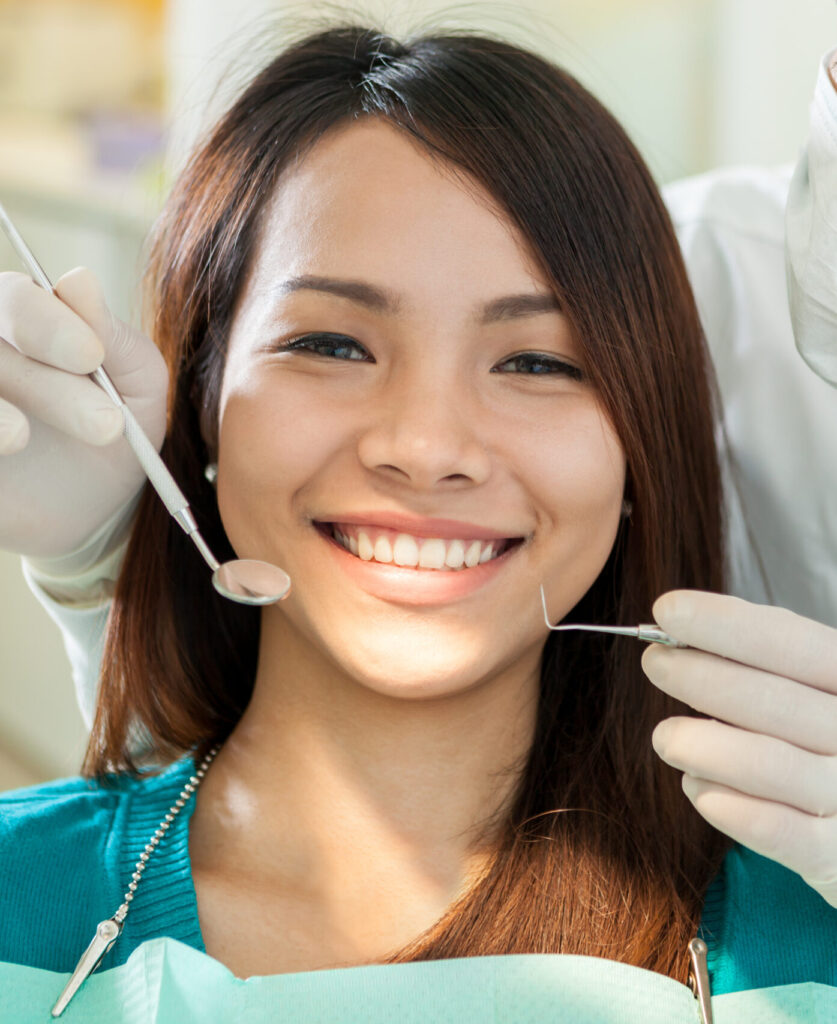 Portrait of smiling asian woman sitting at the dentist