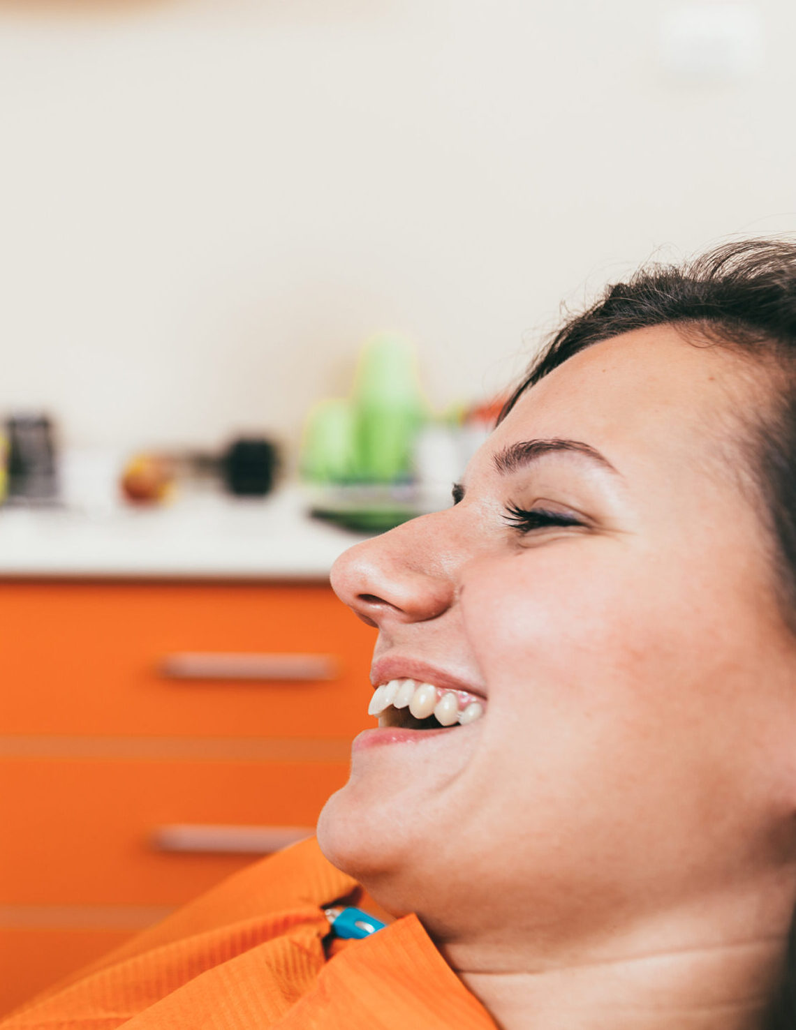 Happy dentist holding a tooth and satisfied patient after tooth extraction