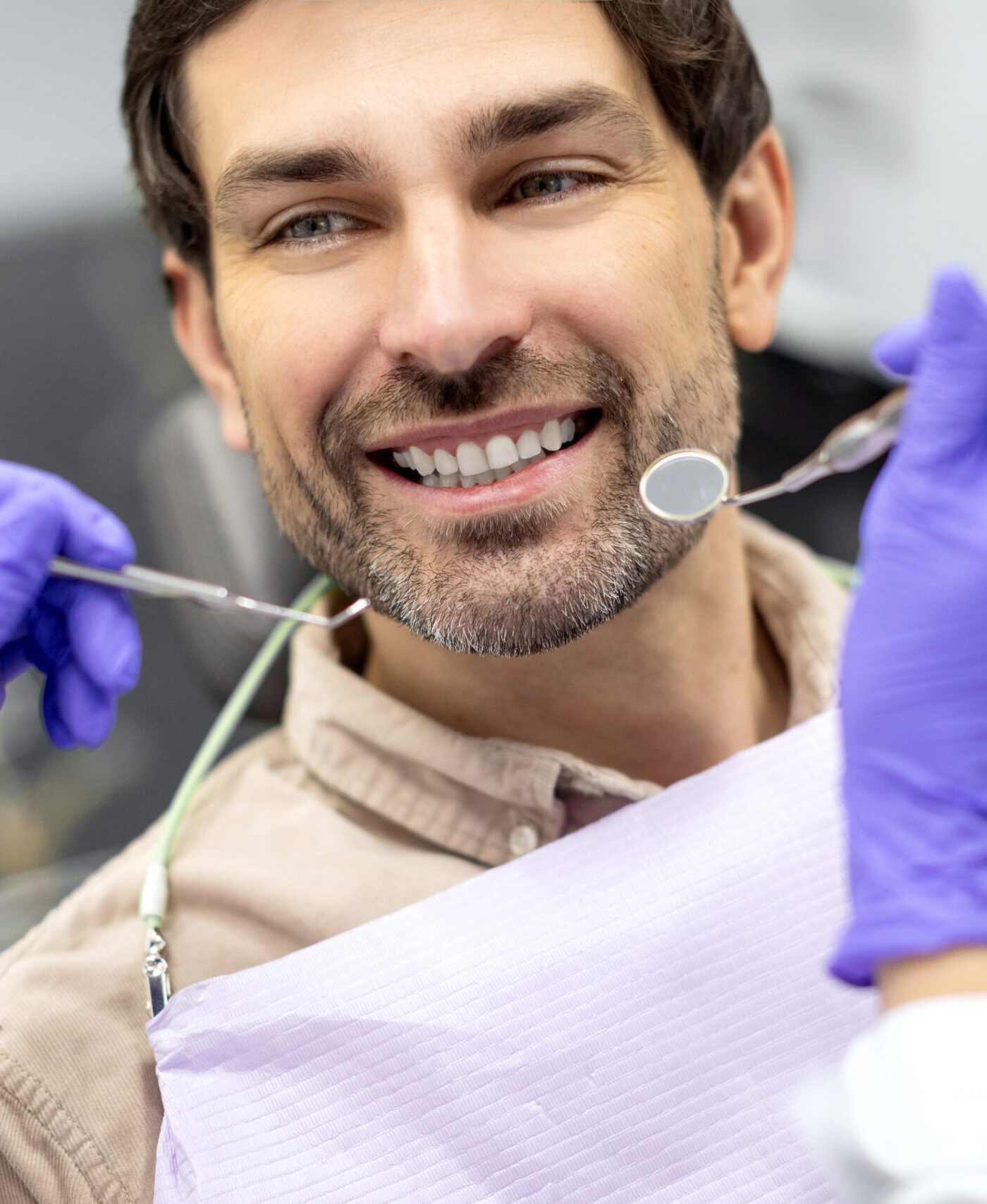 Closeup shot of dentist examining male patients teeth in dental clinic. Man having his teeth examined by female dentist
