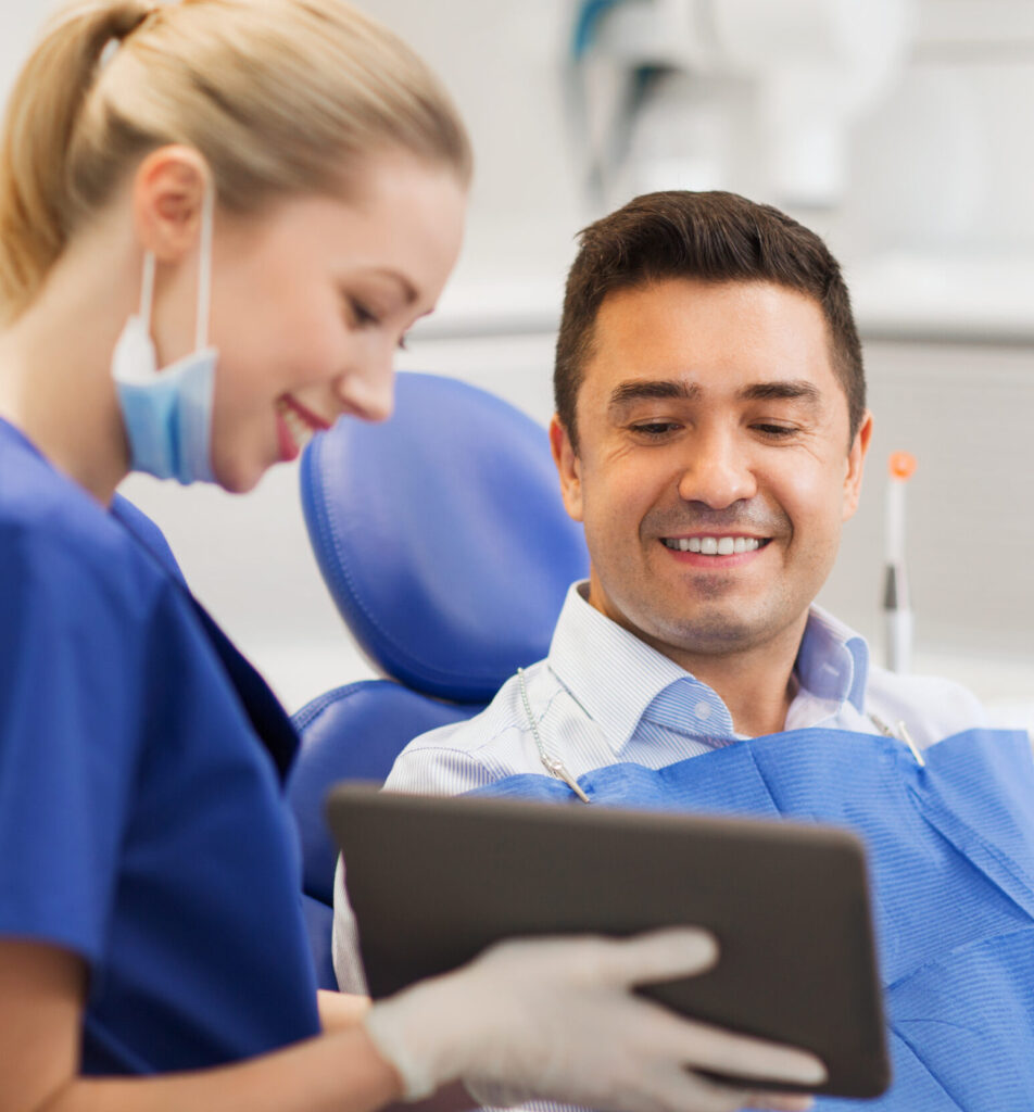 people, medicine, stomatology and health care concept - happy female dentist showing tablet pc computer to male patient at dental clinic office