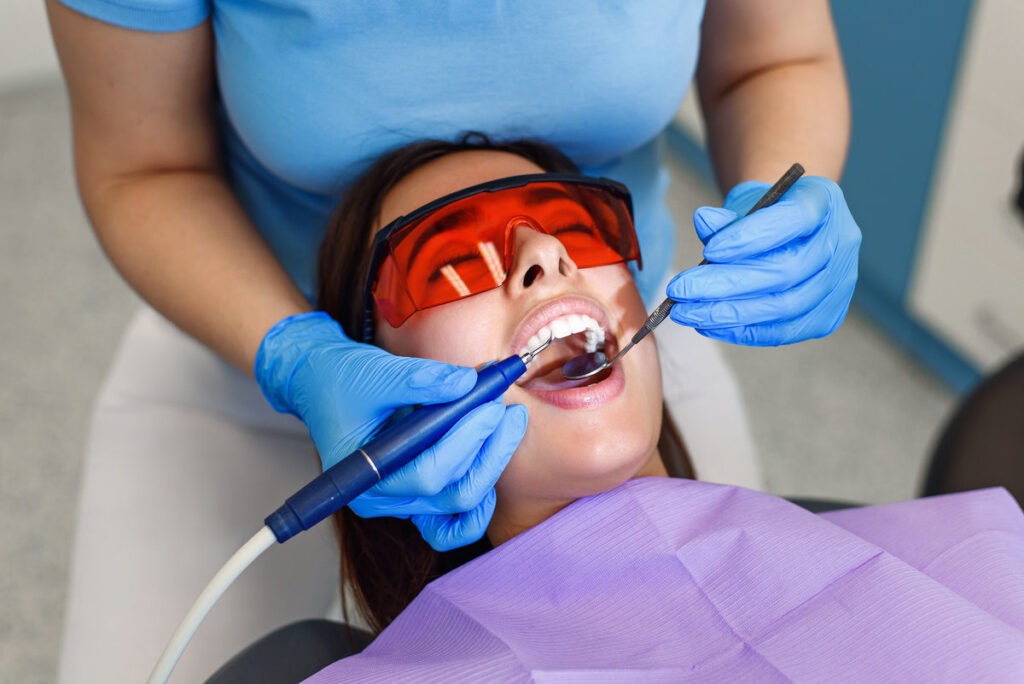 Top view of beautiful young woman with white teeth visits a dentist in a modern clinic. Helthcare concept.